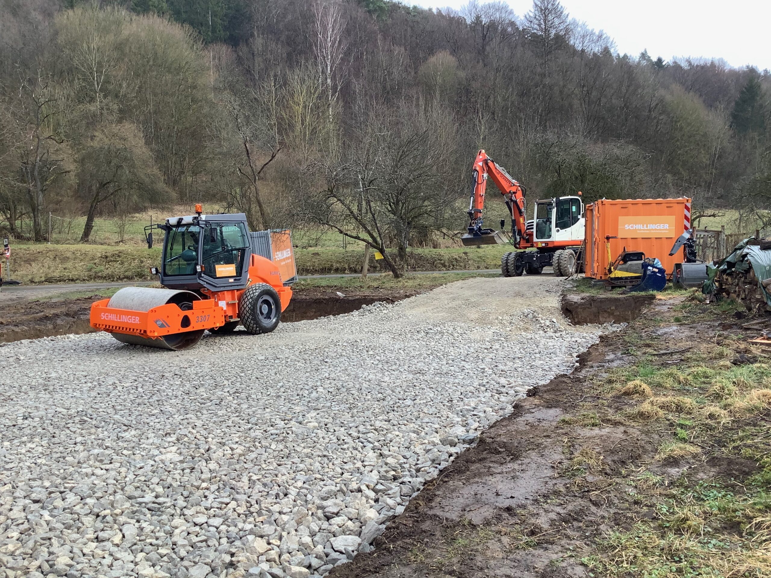 Baustelle im Bereich des Wegebau- oder Tiefbaus der Firma Schillinger Tiefbau mit schwerem Gerät auf einer frisch aufgeschotterten Trasse